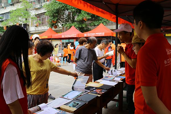 （社区居民翻阅学院《公益摄影—乡土潮汕百村行》课程的优秀作品）