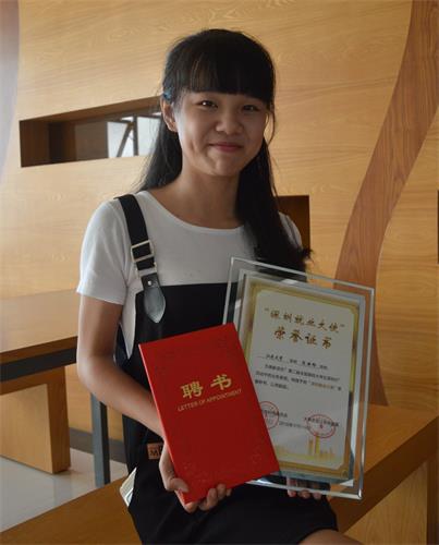 陈丽吟手持深圳行活动中颁发的主席聘书和证书