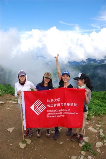 2016 Nepal students hold up a J-School banner on a hilltop near the end of a trek in the Annapurna region of Nepal.